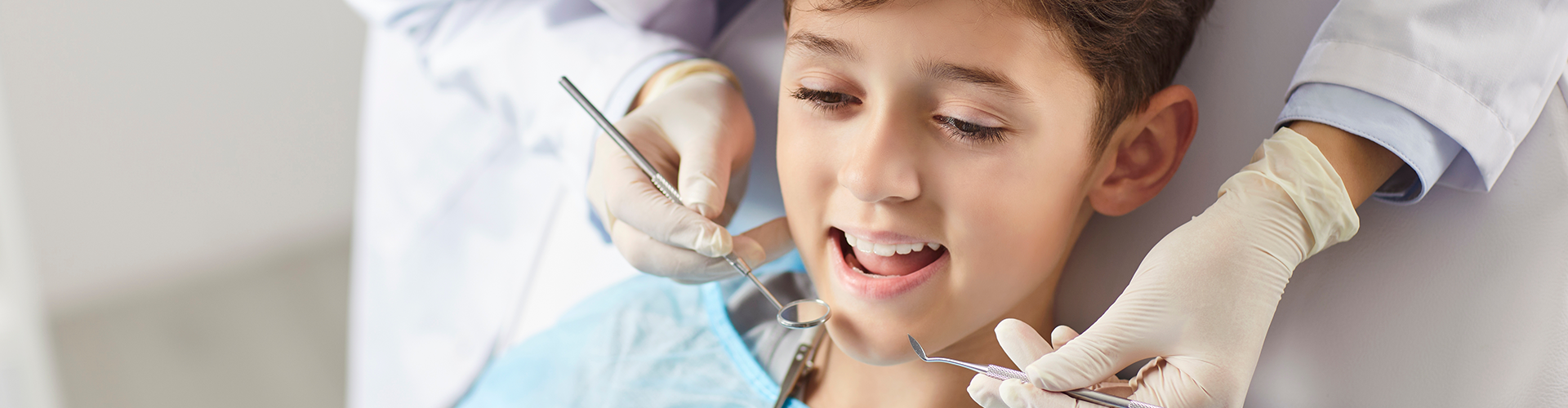 dentist using dental tools in child's mouth